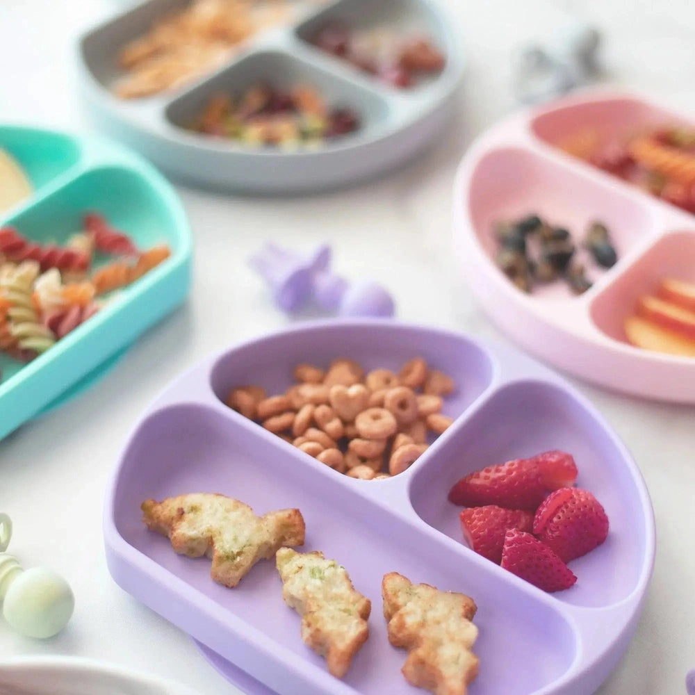 Bumkins Silicone Grip Dish lavender divided baby feeding plate shown with strawberries and snacks in each section.