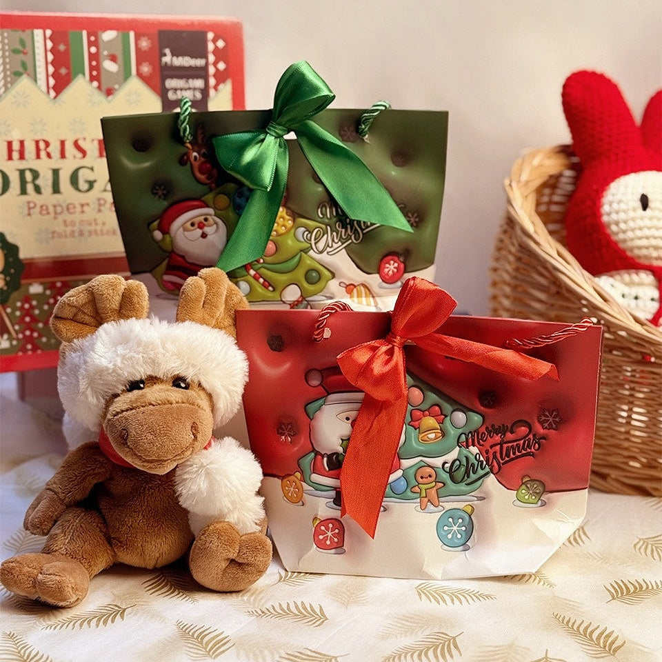 Christmas Stationery Gift Bag by baby enRoute, green bag with ribbon beside red-wrapped bag and plush reindeer.