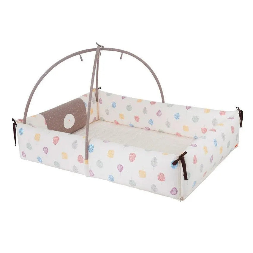 Creamhaus Inua Bumper Bed Guard XL in white with multicolored leaves, padded rails and a grey arch secured by ties.