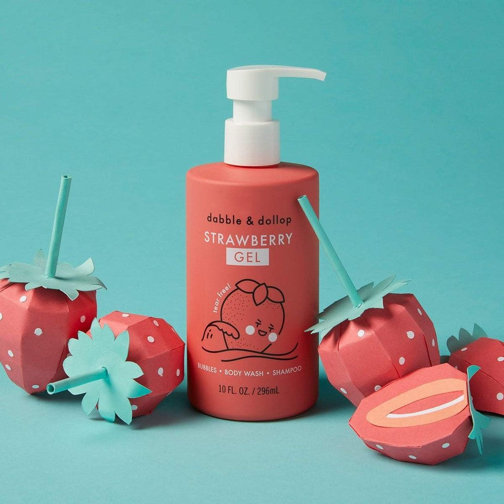 Dabble & Dollop All-Natural Shampoo, Body Wash & Bubbles Strawberry bottle with pump, surrounded by strawberry props.