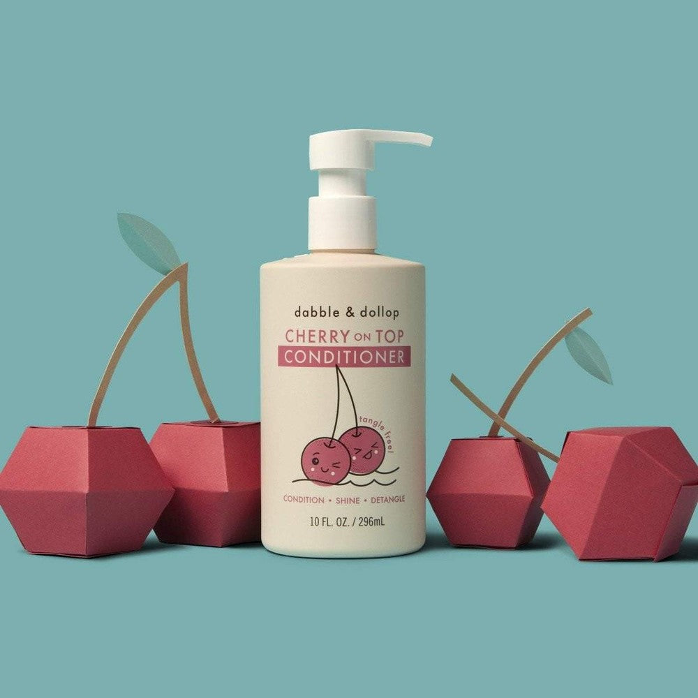 Dabble & Dollop Cherry on Top Conditioner bottle with pump, surrounded by red cherry props.
