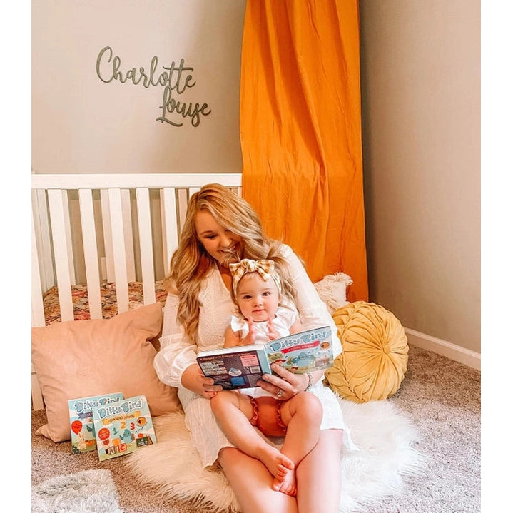 Ditty Bird Sound Book Action Songs USB-C Rechargeable in a cozy nursery as mom reads to baby.