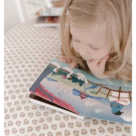 Ditty Bird Sound Book Chinese Poems USB-C Rechargeable with colorful illustrations; child gazes at the open book on a bed.