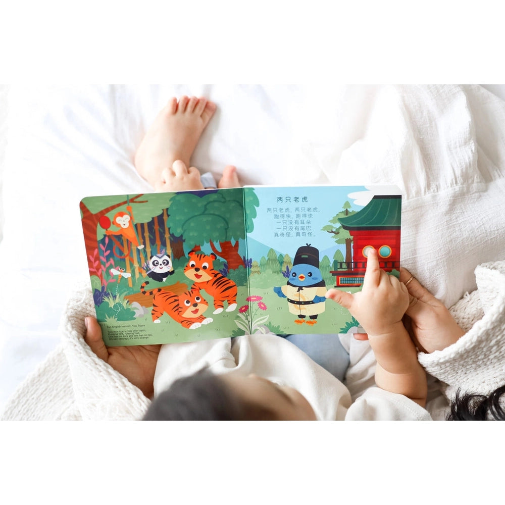 Ditty Bird Sound Book Chinese Songs USB-C Rechargeable; a toddler taps a page amid bright jungle animals.