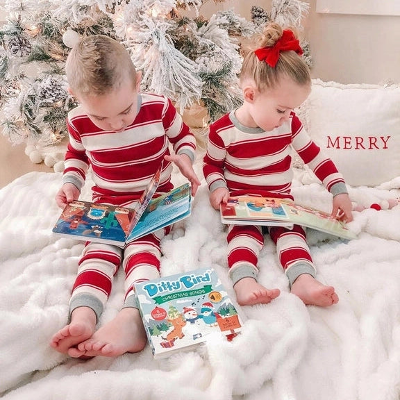 Ditty Bird Sound Book Christmas Songs USB-C Rechargeable; two kids in red striped pajamas read beside a decorated Christmas tree.