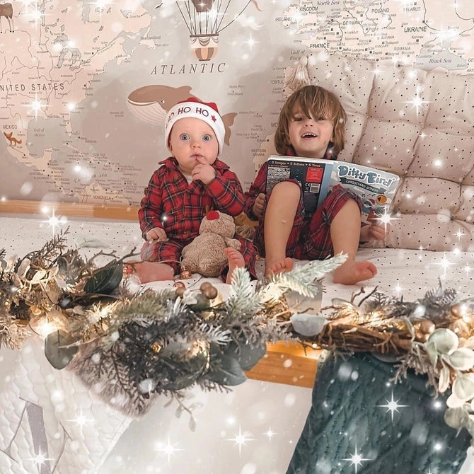 Ditty Bird Sound Book Christmas Songs USB-C Rechargeable toy; two kids in plaid sit on a festive bed with lights.