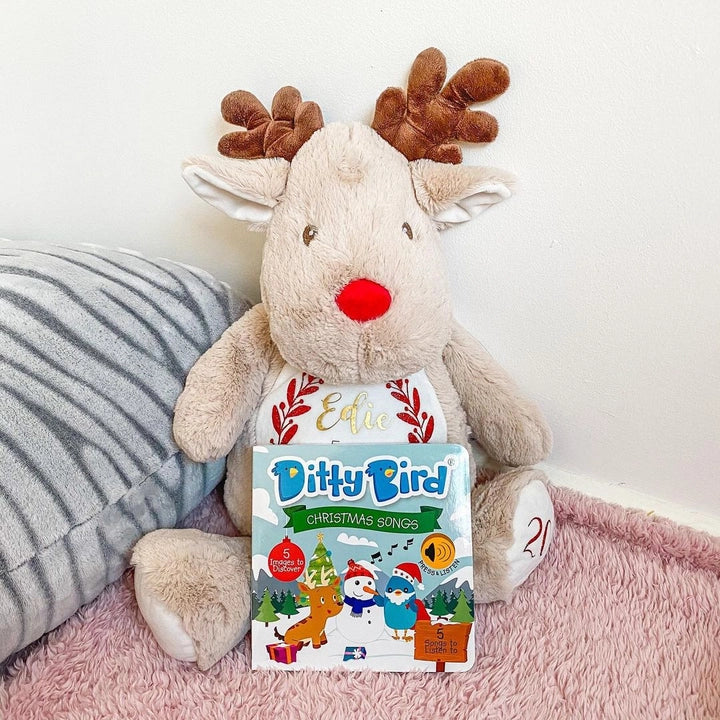 Ditty Bird Sound Book Christmas Songs USB-C Rechargeable; soft beige reindeer plush sits beside the book.