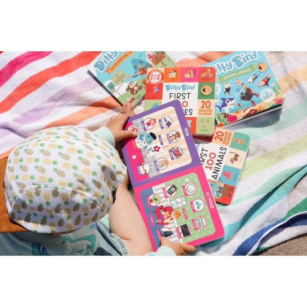 Ditty Bird Sound Book First 100 Words USB-C Rechargeable being explored by a child on a colorful blanket.