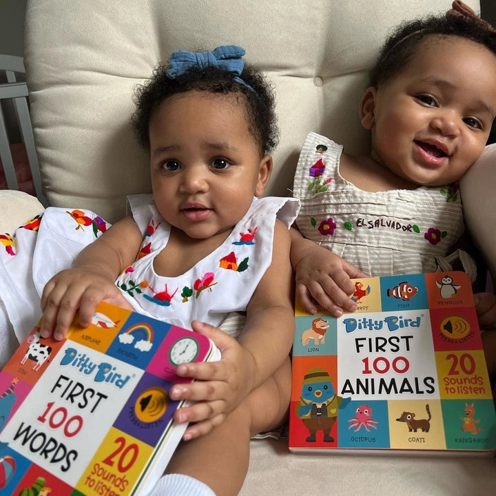 Ditty Bird First 100 Words USB-C rechargeable sound book, two babies smiling while holding colorful pages.