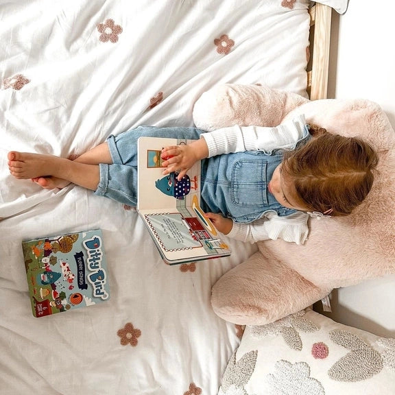 Ditty Bird Sound Book Learning Songs USB-C Rechargeable toy; child taps page to hear songs while reading on bed.