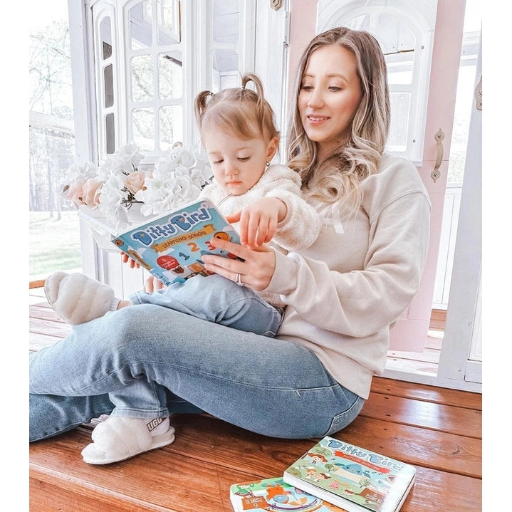 Ditty Bird Sound Book Nature Songs USB-C Rechargeable read by mom and child on a wooden porch.