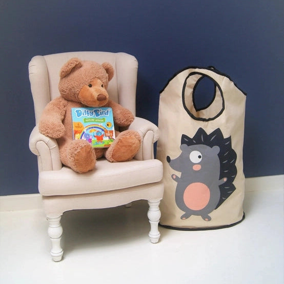Ditty Bird Sound Book Nature Songs USB-C Rechargeable held by a plush bear on a white armchair