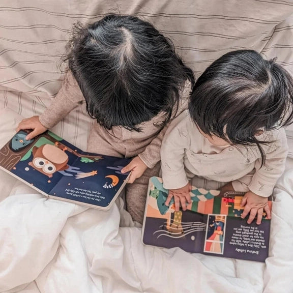 Ditty Bird Sound Book Touch The Cute Animals USB-C Rechargeable being explored by two kids on a couch.
