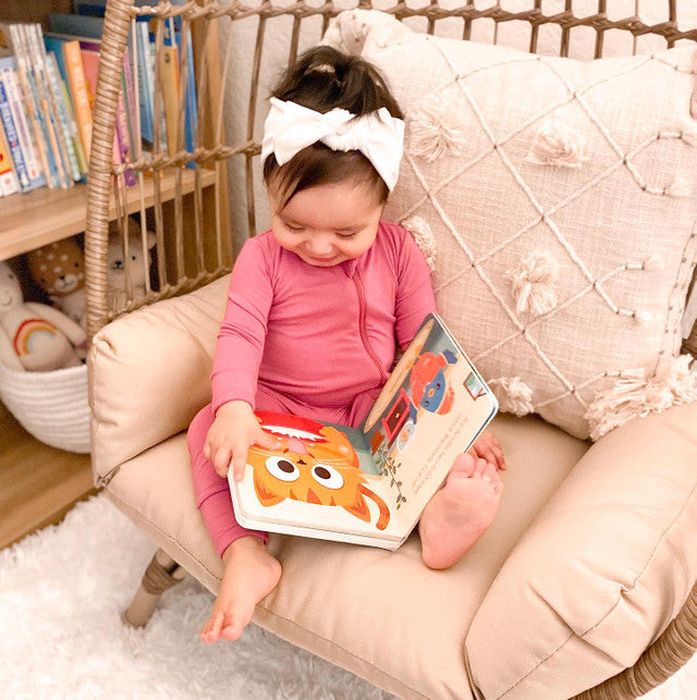 DITTY BIRD Sound Book Touch The Cute Animals USB-C Rechargeable; toddler sits in a soft chair, reading and touching colorful pages.