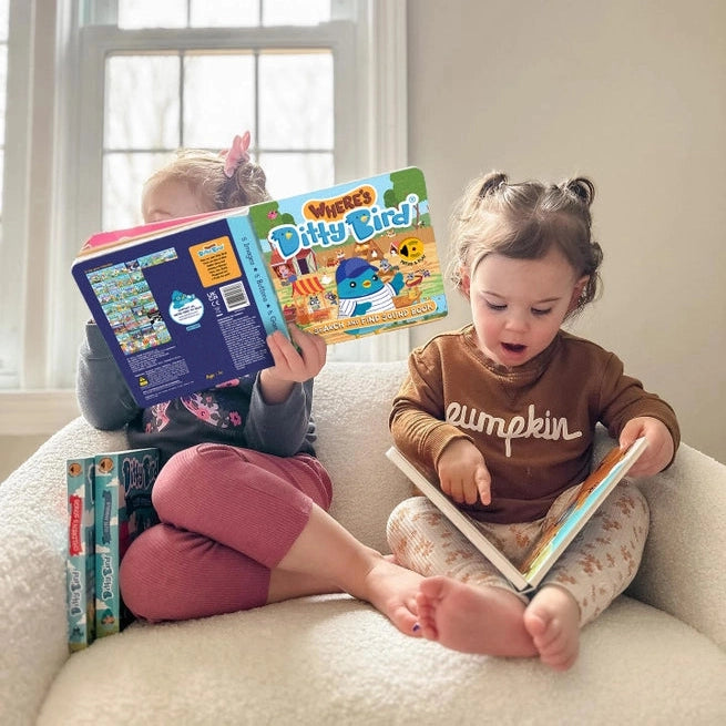 Ditty Bird USB-C Rechargeable Sound Book read by two kids on a cozy couch, a playful educational toy by DITTY BIRD.