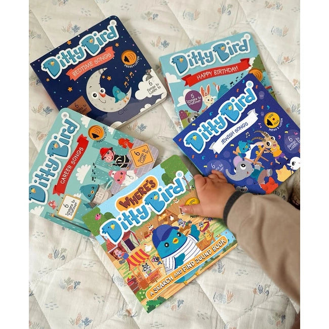 Ditty Bird Sound Book Where's Ditty Bird USB-C Rechargeable, a colorful educational book set on a bed with a child’s hand reaching for one.