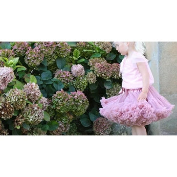 Dolly by Le Petit Tom Pettiskirt Cat Princess Dusty Pink, toddler tutu, twirling beside blooming hydrangeas.