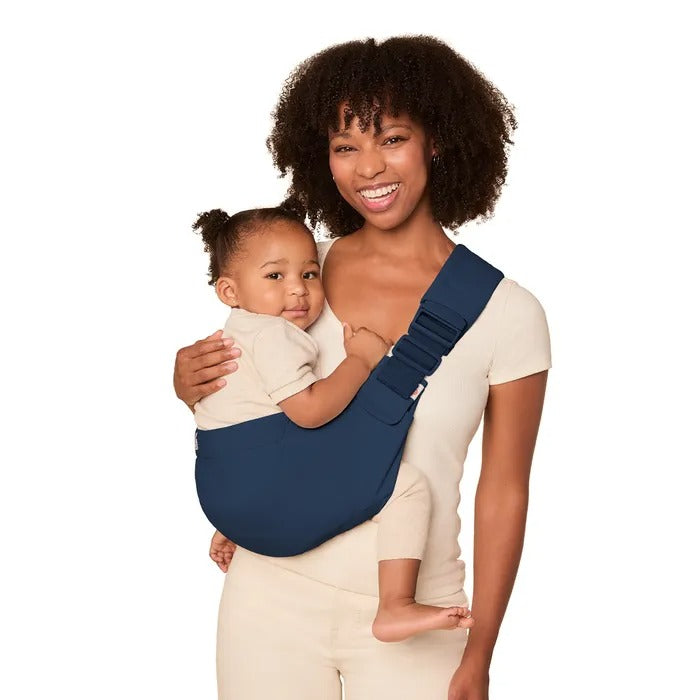 Ergobaby Upsie Sling Carrier in navy blue; mom cradles baby against her chest with a wide, secure shoulder sling.