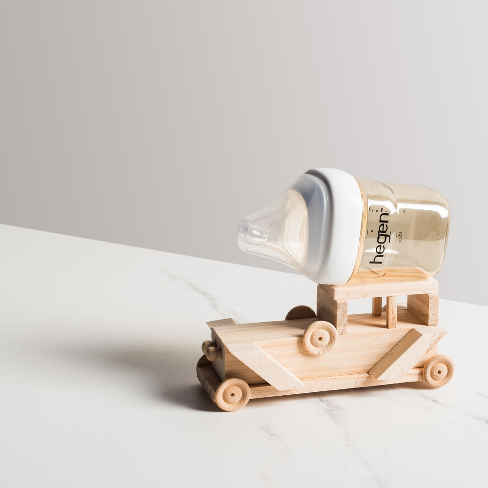 Hegen PCTO PPSU baby feeding bottle 150 ml, 2-pack, resting on a wooden toy car