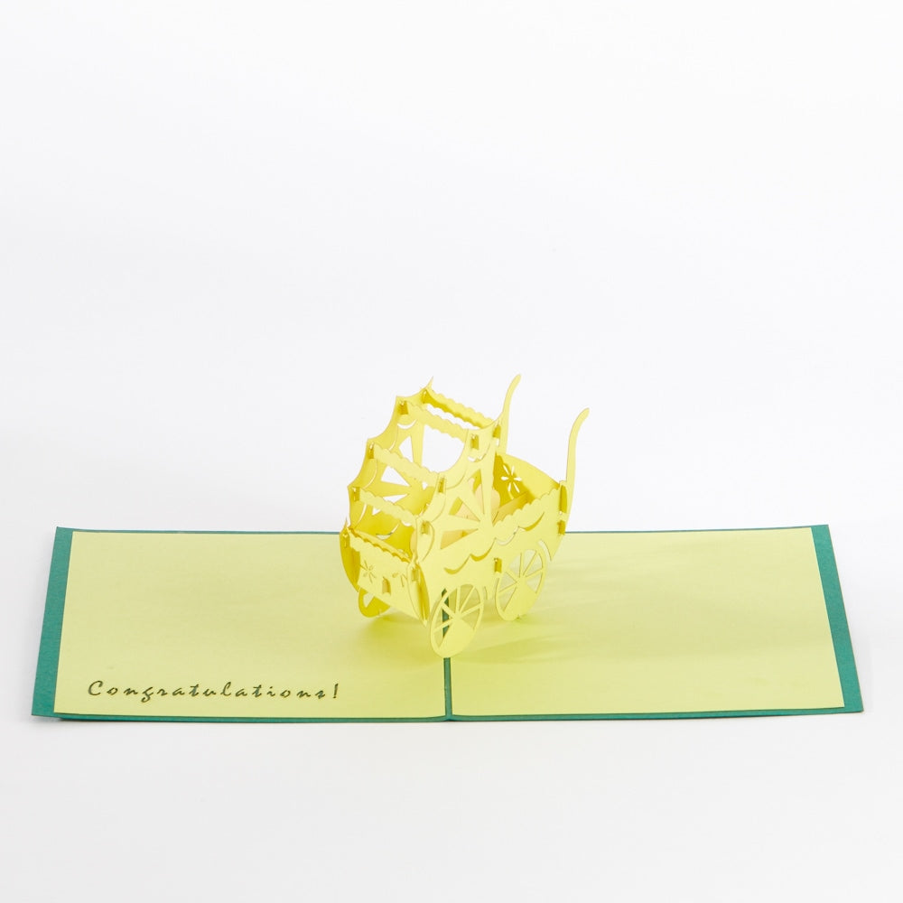 Intricate Greetings Cards Baby Carriage yellow pop-up carriage stands upright on an open congratulation card.