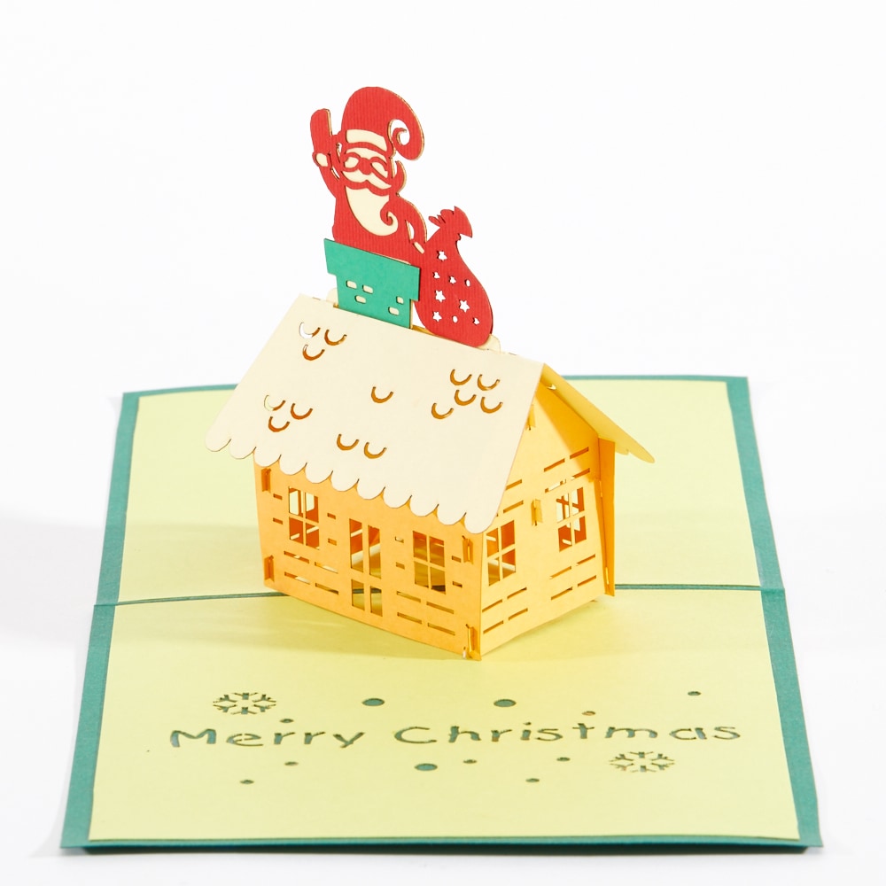 Intricate Greetings Cards Santa On The Roof pop-up card featuring a yellow cottage and Santa on the roof.