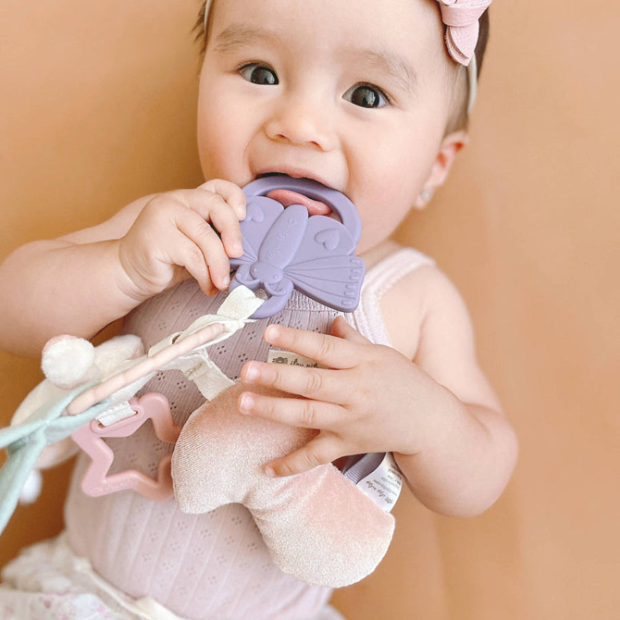 Itzy Ritzy Bitzy Busy Ring teething toy in lavender with a bunny shape and soft plush attachments.
