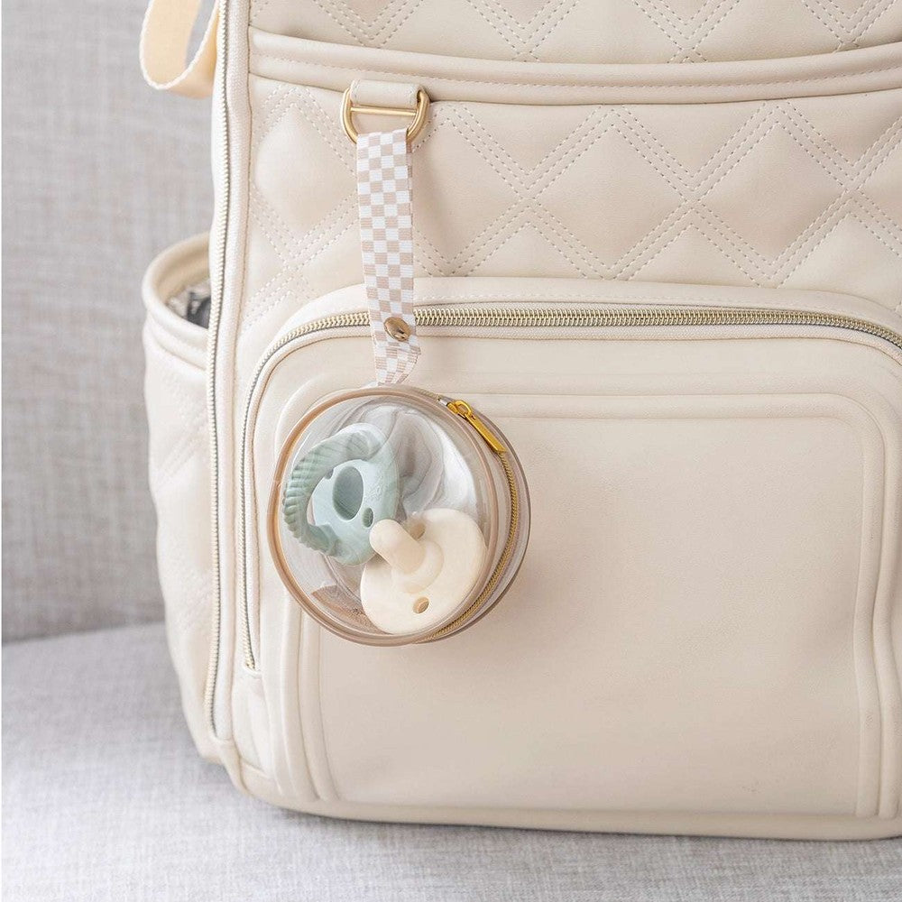 Itzy Ritzy paci case on beige quilted backpack with clear round clip and checkered strap