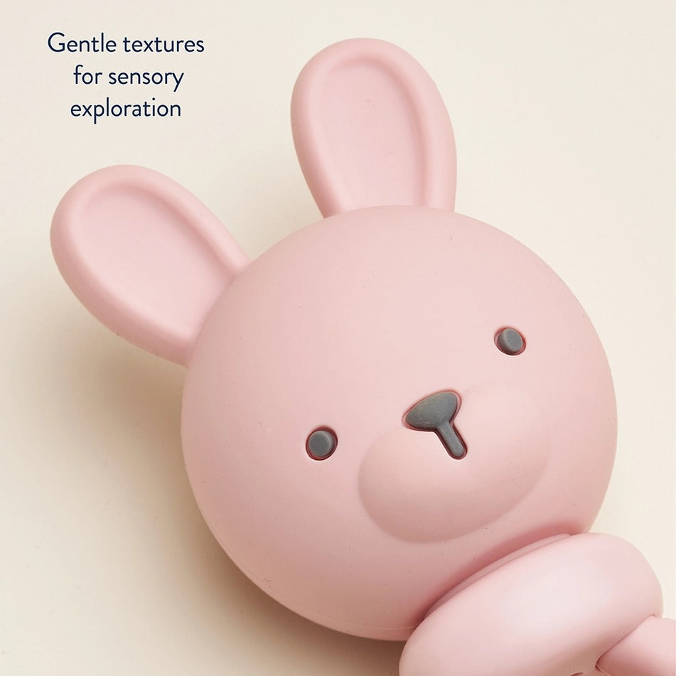 Itzy Ritzy Sweetie Rattle Pink Bunny for sensory exploration; close-up of soft pink head and ears.