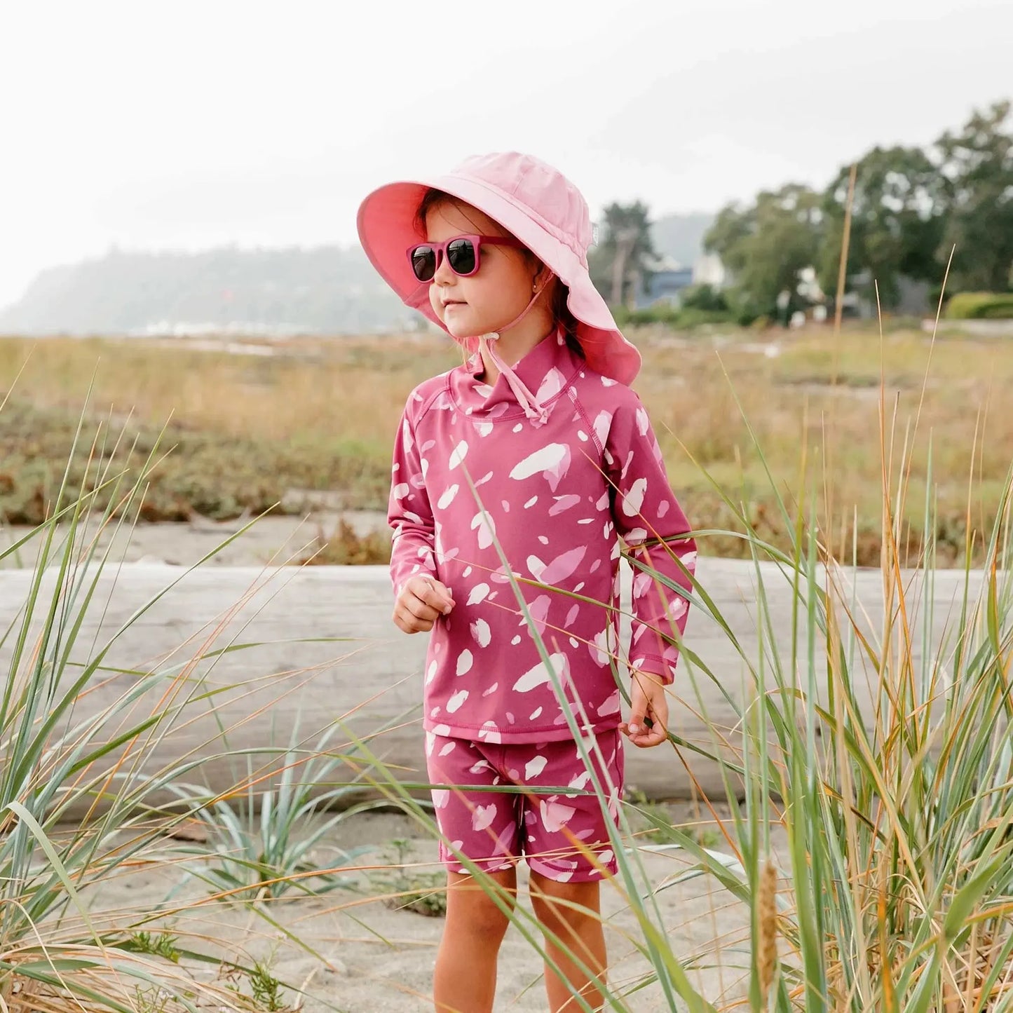 Jan & Jul kids UV rashguard set pink petals; child wearing pink hat