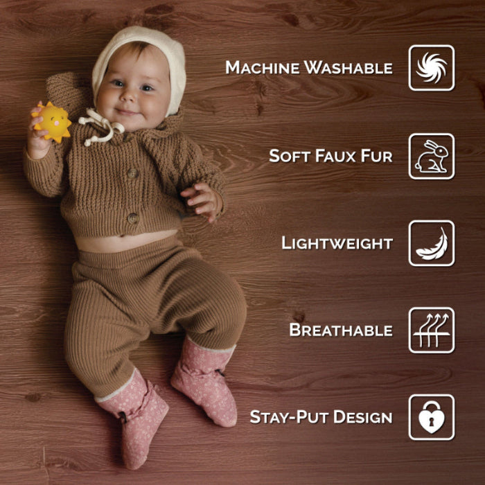 JAN & JUL Baby Stay-Put Winter Booties Space Dinos in dusty pink on a baby, showing soft faux fur and stay-put design.