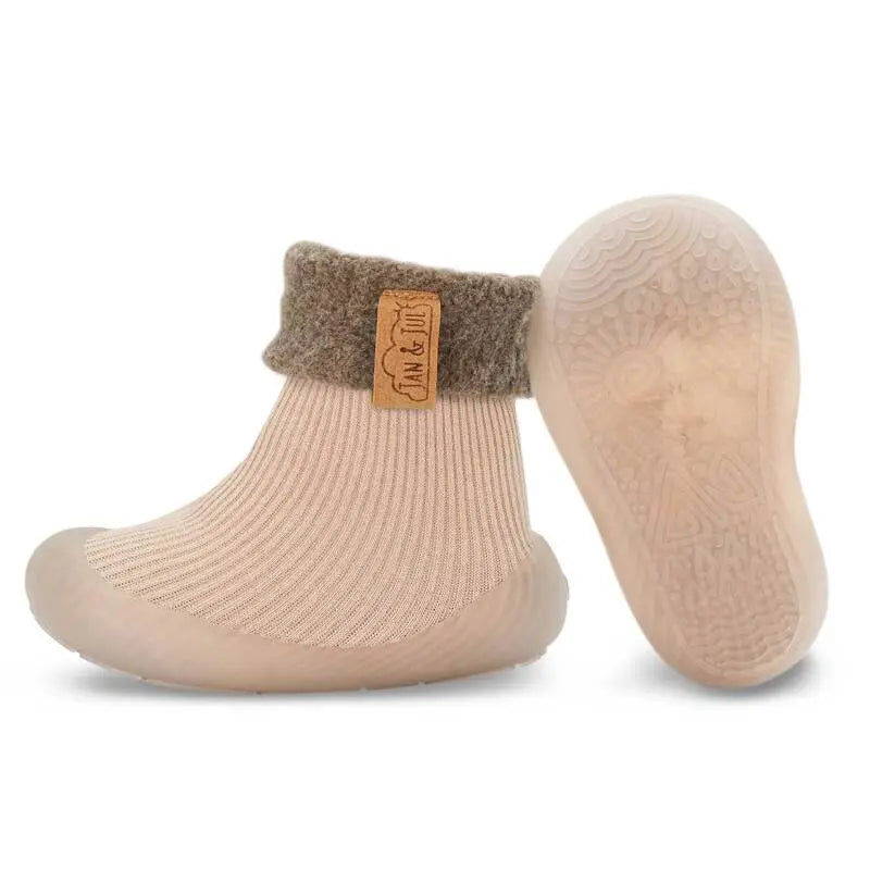 Jan & Jul Cozy Sock Shoes Oat; beige knit baby sock shoes with grey cuff and flexible rubber sole on toddler feet
