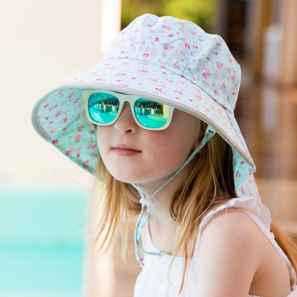JAN & JUL Kids Cotton Adventure Hat Retro Rose, light blue floral with chin strap, worn with turquoise mirrored sunglasses.