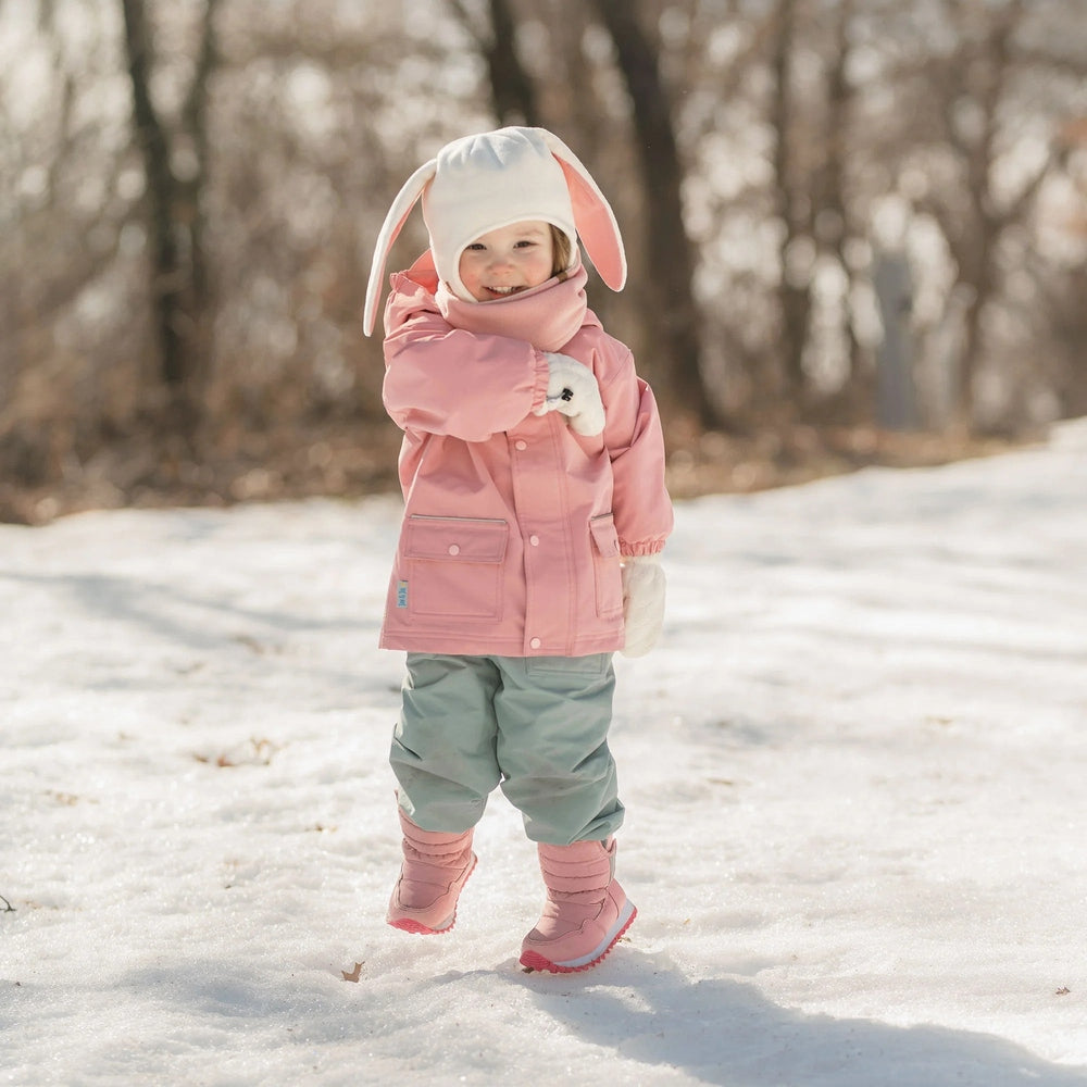 JAN & JUL Kids Tall Puffy Winter Boots in dusty pink; toddler walking through the snowy ground.