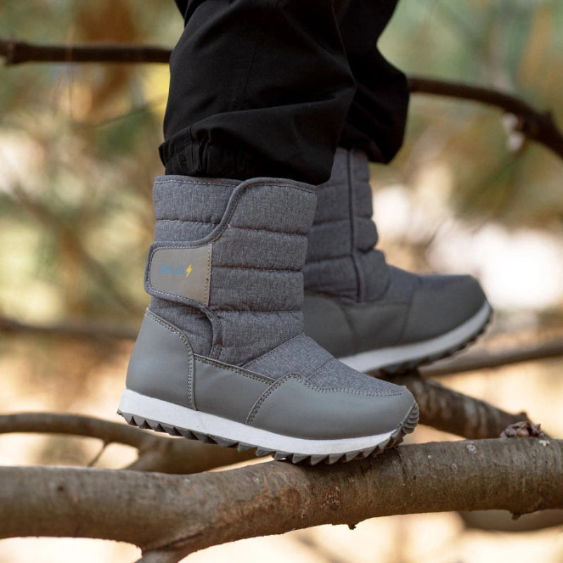 Jan & Jul Kids Tall Puffy Winter Boots Heather Grey, quilted shaft and rugged sole, child stepping on a branch.