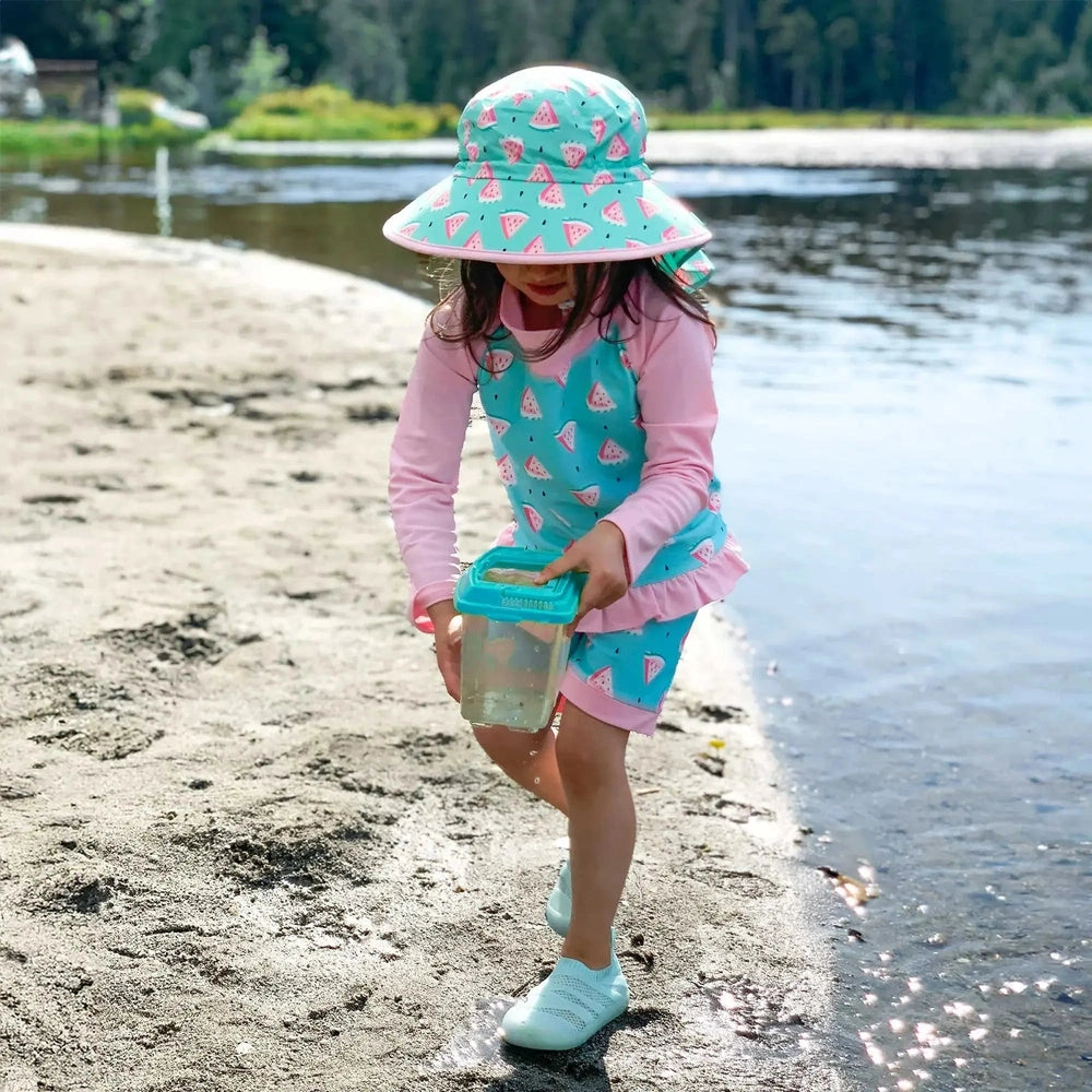 Jan & Jul Kids Water Repellent Adventure Hat Watermelon pattern; turquoise aqua with pink watermelons on a girl at the beach.