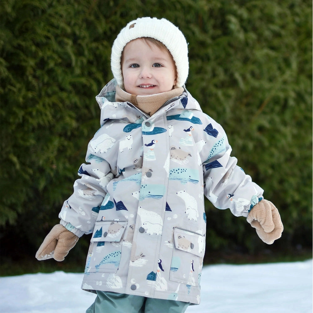 Jan & Jul Polar Pals waterproof rain jacket for kids in light gray with polar print, worn by a toddler in a white knit hat