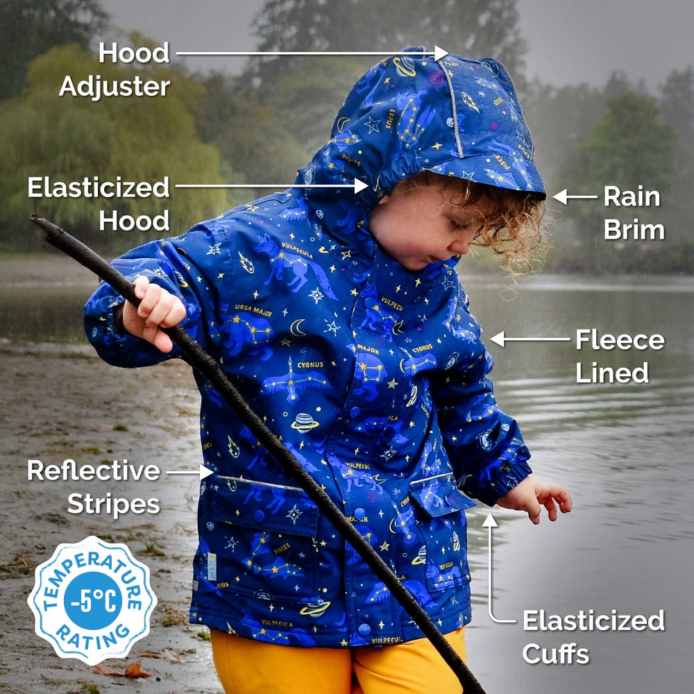 JAN & JUL rain jacket for kids in blue space-dino print; fleece-lined hood, elastic cuffs, reflective stripes, worn by child