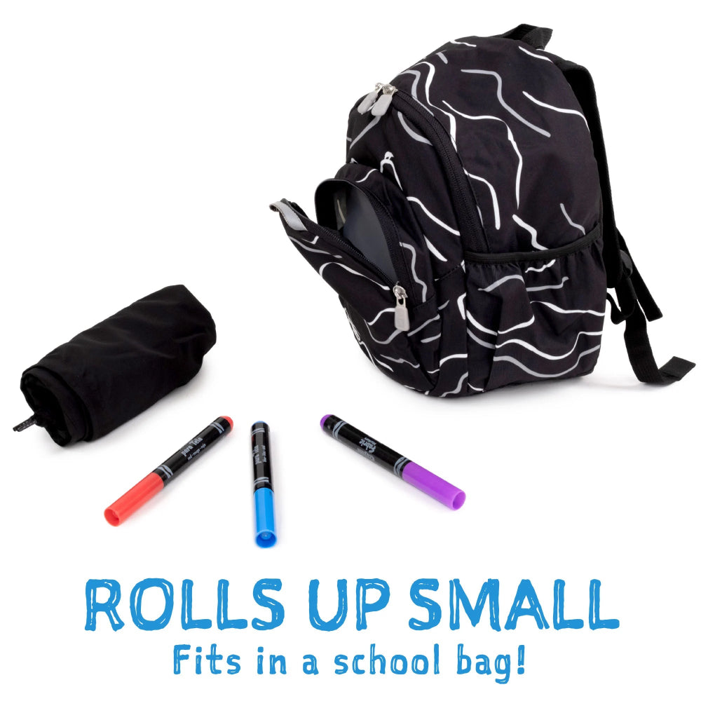 Jan & Jul Waterproof Puddle Dry Rain Pants Wolf And Bear rolled up beside a black backpack, showing compact storage.