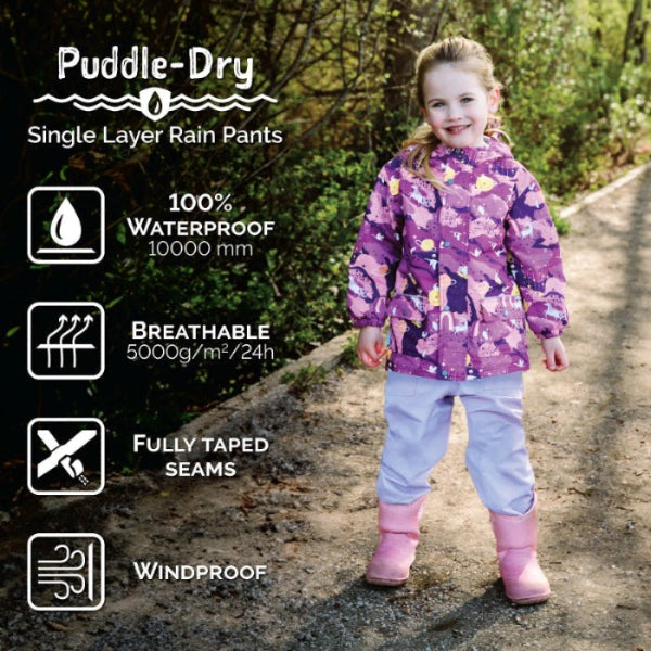 Jan & Jul Waterproof Puddle Dry Rain Pants for kids, purple, fully taped seams; child strolls a damp path in pink boots showing 10000 mm waterproof and breathable.