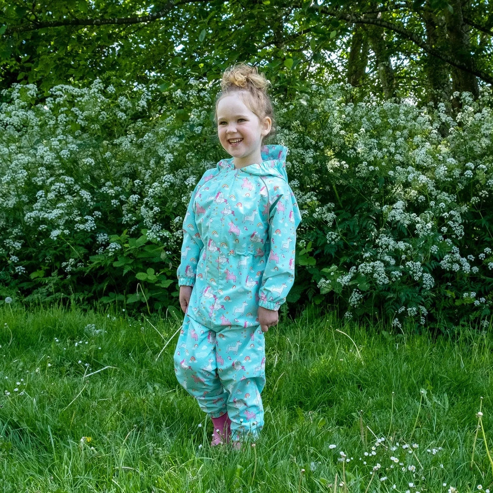 Jan & Jul Waterproof Puddle Dry Rain Pants Unicorn for kids in turquoise; a girl stands in a grassy meadow.