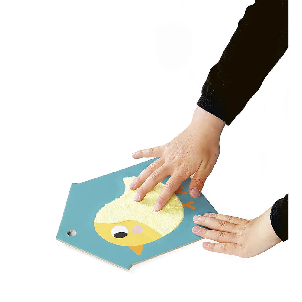 Janod Tactile Cards Set: blue card with a yellow chick; toddler palpates the textured surface.