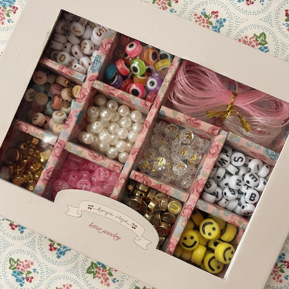 Konges Slojd Abc Jewellery Set in a pink floral box; kids' beads, pearls, letters, and smiley charms neatly organized.