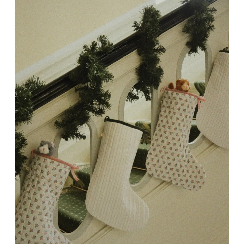 Konges Slojd Baby Animals plush toys shaped as cozy stockings hung along a garland by a mirror.