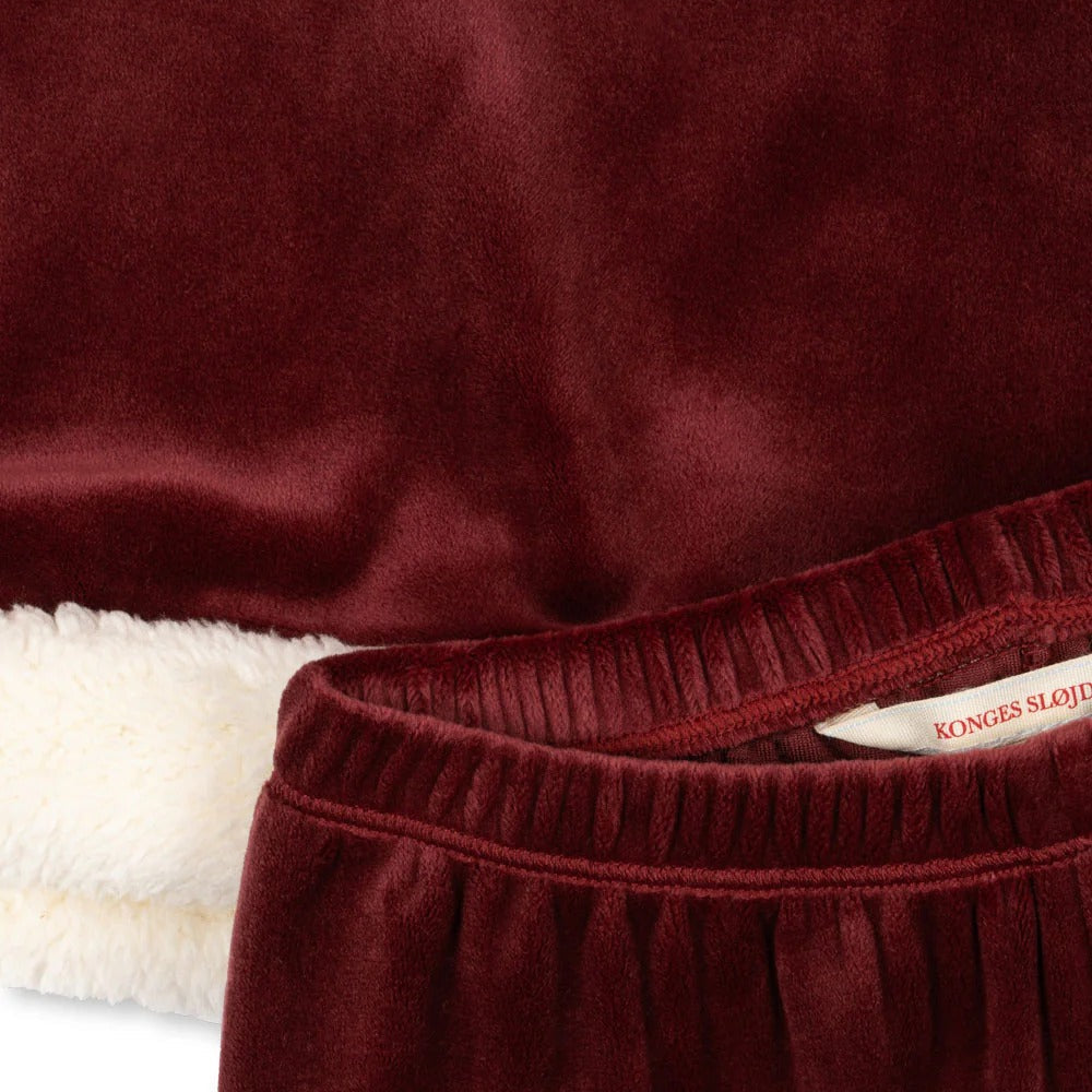 Konges Slojd Christmas Set Red Dahlia baby outfit in burgundy velvet with white faux‑fur lining, tag visible.