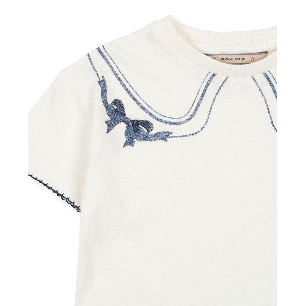 Konges Slojd Era Tee off-white with blue bow collar print, neckline detail visible on a soft baby top