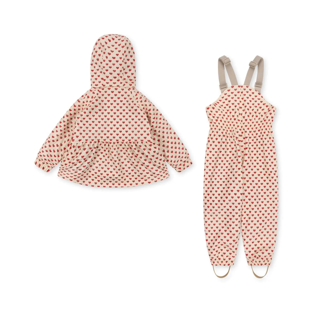 Konges Slojd Rainy Palme Set Coeur Rouge heart-print hooded jacket and matching pants with suspenders laid flat.