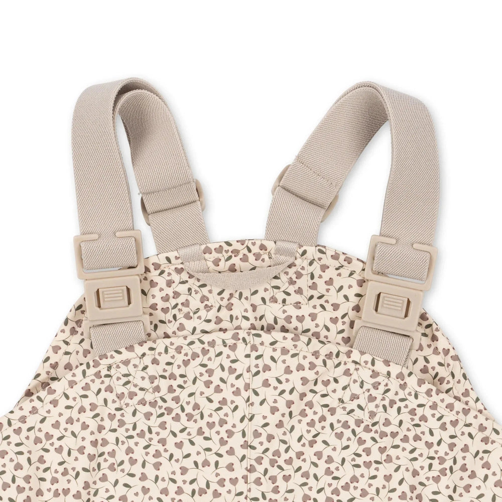 Konges Slojd Rainy Palme Milk Tank overalls with beige adjustable straps buckled at shoulders.