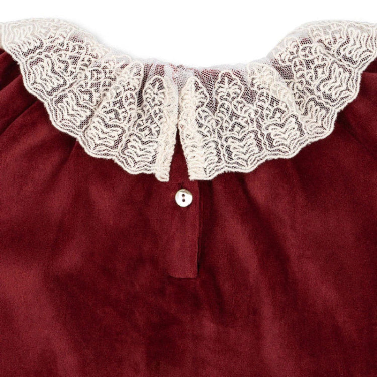 Konges Slojd Venola Romper Red Dahlia, burgundy fabric with lace collar and visible button placket.