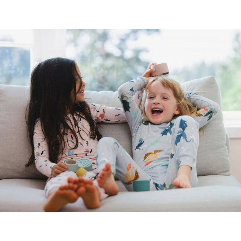 Loulou Lollipop Long Sleeve Pajama Set Magical Dragons: two kids in dragon-print pastel sleepwear giggling on couch.