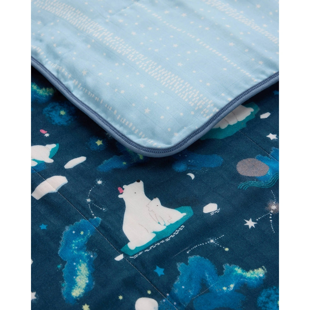 LOULOU LOLLIPOP Muslin Quilt Blanket: navy starry polar-bear design with a light-blue top layer draping over the quilt.